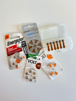 Mehrere Blisterpackungen mit Hörgerätebatterien verschiedener Marken und Typen liegen nebeneinander.